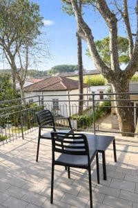 two benches and a table on a patio at Hotel Villa Tina Easy Stay B&B in Cesenatico