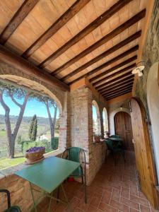 an outdoor patio with a table and chairs and a wooden ceiling at Fattoria Di Pancole in San Gimignano