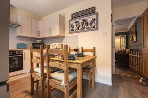 a kitchen with a wooden table with chairs and a dining room at Boar Edge Cottage in Richmond