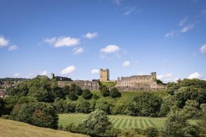 a castle on top of a hill with trees at Boar Edge Cottage in Richmond