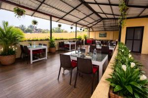 a restaurant with tables and chairs and plants at Praia Da Oura Boutique Resort ,Goa in Majorda