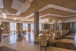 a restaurant with tables and chairs in a building at Hotel Franca Tivat in Tivat