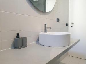 a white bathroom with a sink and a mirror at New N3-House by Anthea Homes in Casièr