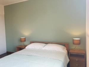 a bedroom with a bed with two nightstands and two lamps at New N3-House by Anthea Homes in Casièr