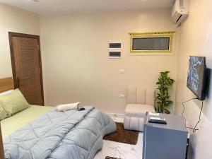 a bedroom with a bed and a flat screen tv at Nefertiti guest house view pyramids in Cairo