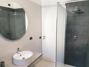 a bathroom with a sink and a glass shower at New N3-House by Anthea Homes in Casièr
