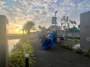 a playground with a blue slide on the beach at Casita Luna in San Juan