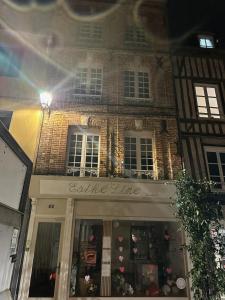 a store front of a brick building at night at Le 8 Chaussée Honfleur in Honfleur