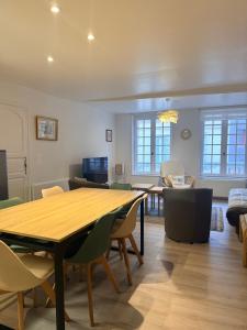 a dining room and living room with a table and chairs at Le 8 Chaussée Honfleur in Honfleur