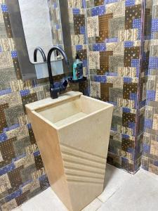 a sink in a bathroom with a tiled wall at Nefertiti guest house view pyramids in Cairo +140 photos