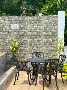 a black table and chairs with a brick wall at Thani's Little Cabin Rental - Native Room in Caibiran +1 photo