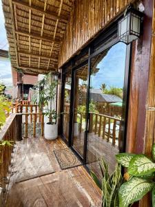 an open door to a balcony with plants at Thani's Little Cabin Rental - Native Room in Caibiran