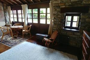 a living room with a table and chairs and windows at El Verdecillo de Rodiles, Villaviciosa in Selorio