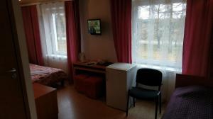a bedroom with a desk and a chair and a window at Berzu aleja in Birštonas