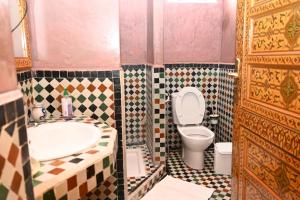 a bathroom with a sink and a toilet and a tub at Dar Maya Original Suite & Spa in Fez