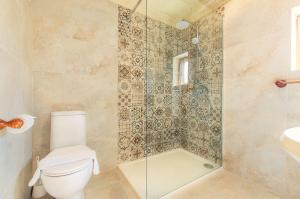 a bathroom with a shower and a toilet and a sink at Il-Kampnar Gozo Farmhouse with Private Pool in Sannat