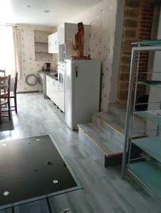 a kitchen with a white refrigerator and a table at le chêne in Créancey +3 photos