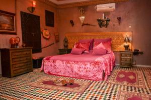 a bedroom with a bed with a pink bedspread at Dar Maya Original Suite & Spa in Fez