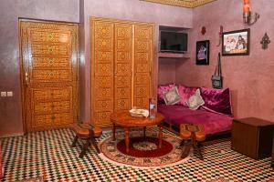 a living room with a purple couch and a table at Dar Maya Original Suite & Spa in Fez +3 photos