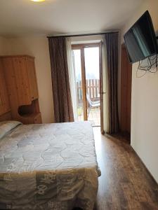 a bedroom with a bed and a sliding glass door at B&B Ledro AFFITTACAMERE in Mezzolago