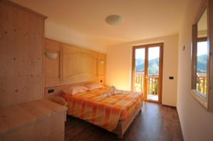 a bedroom with a bed and a large window at B&B Ledro AFFITTACAMERE in Mezzolago