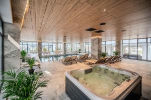 a large room with a hot tub in a building at Eleven Odyssey Apartment in Năvodari