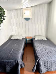 two beds sitting next to each other in a room at Vuohensaari, Rantatalo 6 in Salo