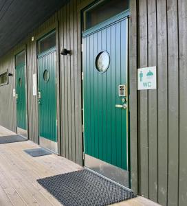 a building with green doors and a sign on it at Vuohensaari, Rantatalo 6 in Salo +3 photos