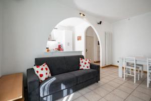 a living room with a black couch and a table at Dolce Teresa in Mandello del Lario