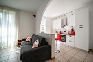 a living room with a couch and a kitchen at Dolce Teresa in Mandello del Lario
