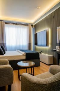 a hotel room with a bed and a couch and chairs at Inn City Park Hotel in Burunabat