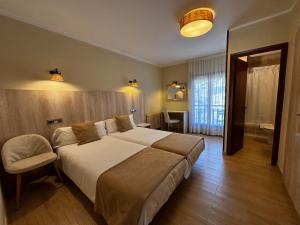 a bedroom with a large bed and a chair at La Noguera de Llavorsí in Llavorsí