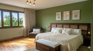a bedroom with green walls and a bed and a chair at Hotel El Mirlo Blanco in Candeleda +59 photos