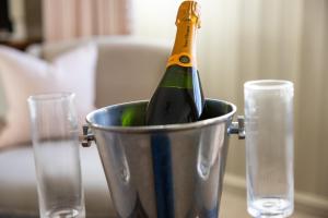 a bottle of champagne in a bucket next to two glasses at The Cavendish Arms in Cartmel