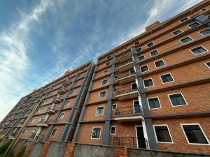 a tall brick building with windows and a sky at Ibis Stays in Naziba
