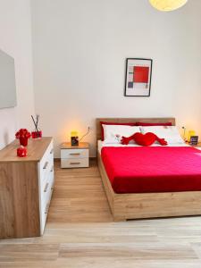 a bedroom with a bed with a red bedspread at Petali Rosa - Dimora Antica Roma in Polignano a Mare