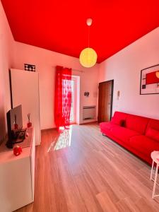 a red couch in a living room with a red ceiling at Petali Rosa - Dimora Antica Roma in Polignano a Mare