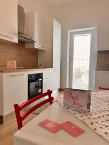 a kitchen with a table with a book on it at Petali Rosa - Dimora Antica Roma in Polignano a Mare