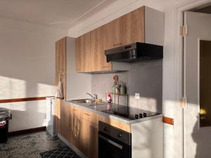 a kitchen with wooden cabinets and a sink and a stove at Gîte Les Mirabelliers à Morville Hébergement cosy in Morville