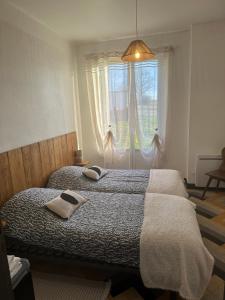 a bedroom with a bed with two towels on it at Gîte Les Mirabelliers à Morville Hébergement cosy in Morville