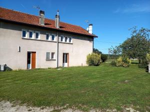 a white house with a grassy yard in front of it at Gîte Les Mirabelliers à Morville Hébergement cosy in Morville