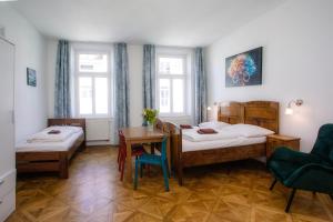 a bedroom with two beds and a table and chairs at Cuba Bar & Hostel in České Budějovice