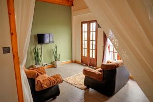 a living room with two chairs and a television at The Mount View Single Tree Hotel in Nuwara Eliya