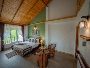 a bedroom with a bed and a table in a room at The Mount View Single Tree Hotel in Nuwara Eliya