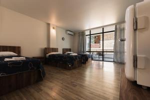 a hotel room with two beds and a balcony at Kartuli Suli in Ureki