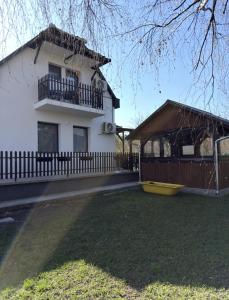 a white house with a balcony and a yard at Bogatu Vendégház in Bogács