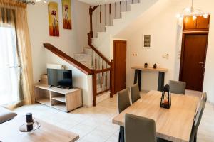 a living room with a dining table and a tv at Anthemia Luxurious Villa in Iraklitsa