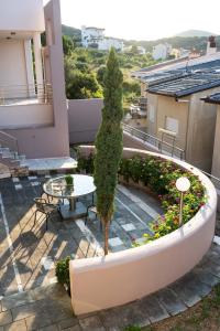 a table and a tree on a balcony at Anthemia Luxurious Villa in Iraklitsa
