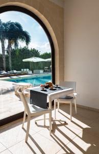 a dining room with a table and chairs and a pool at Tenuta San Nicola in Novoli