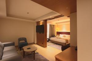 a hotel room with a bed and a living room at Hotel Palacio Paltan Bazaar in Guwahati